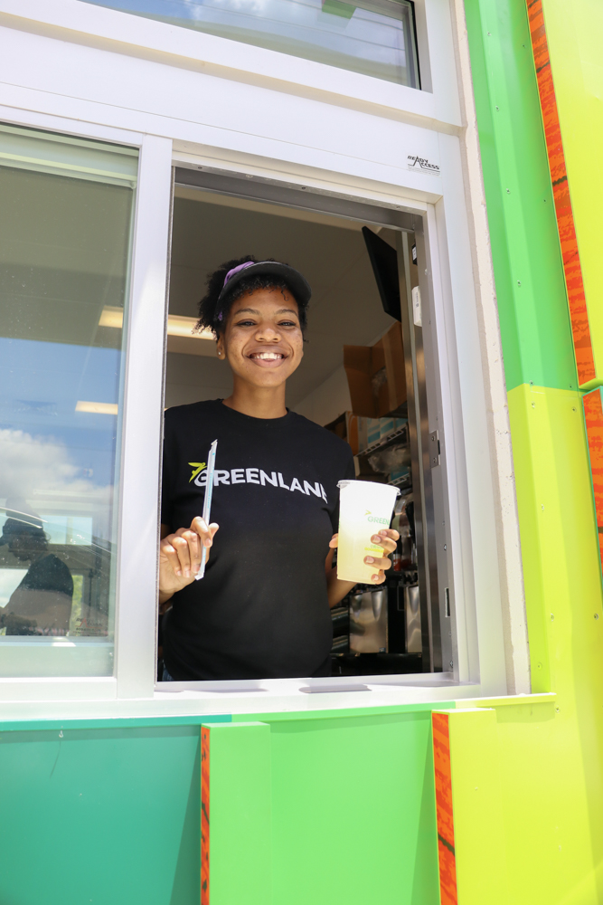 Friendly Staff Drive-Thru Service – GREENLANE Tampa Restaurant Photography GREENLANE team member smiling at drive-thru window holding drink and straw