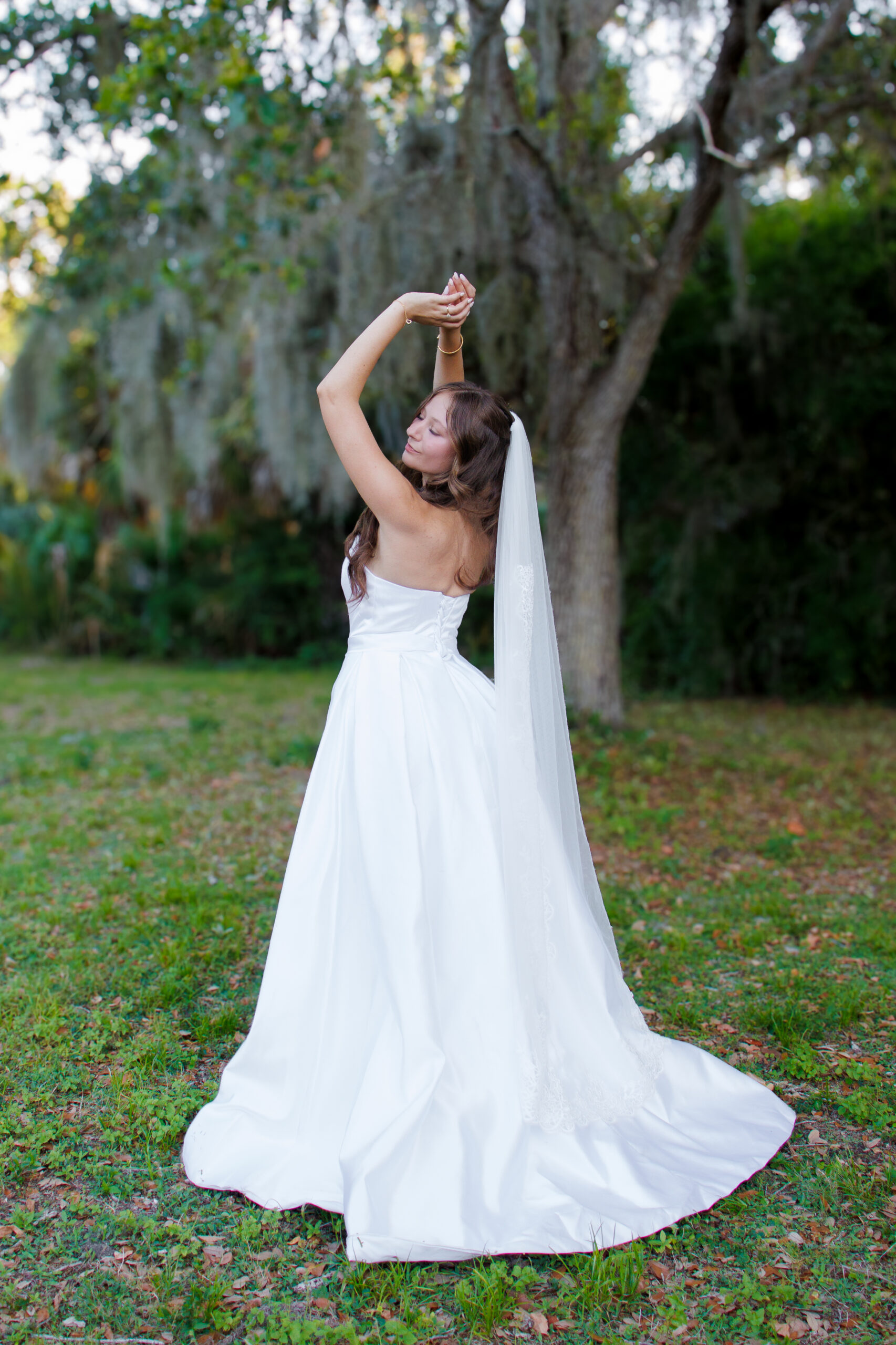 Outdoor bridal portrait with veil flowing in Tampa Bay Bride smiling in white wedding dress with veil in Tampa Bay