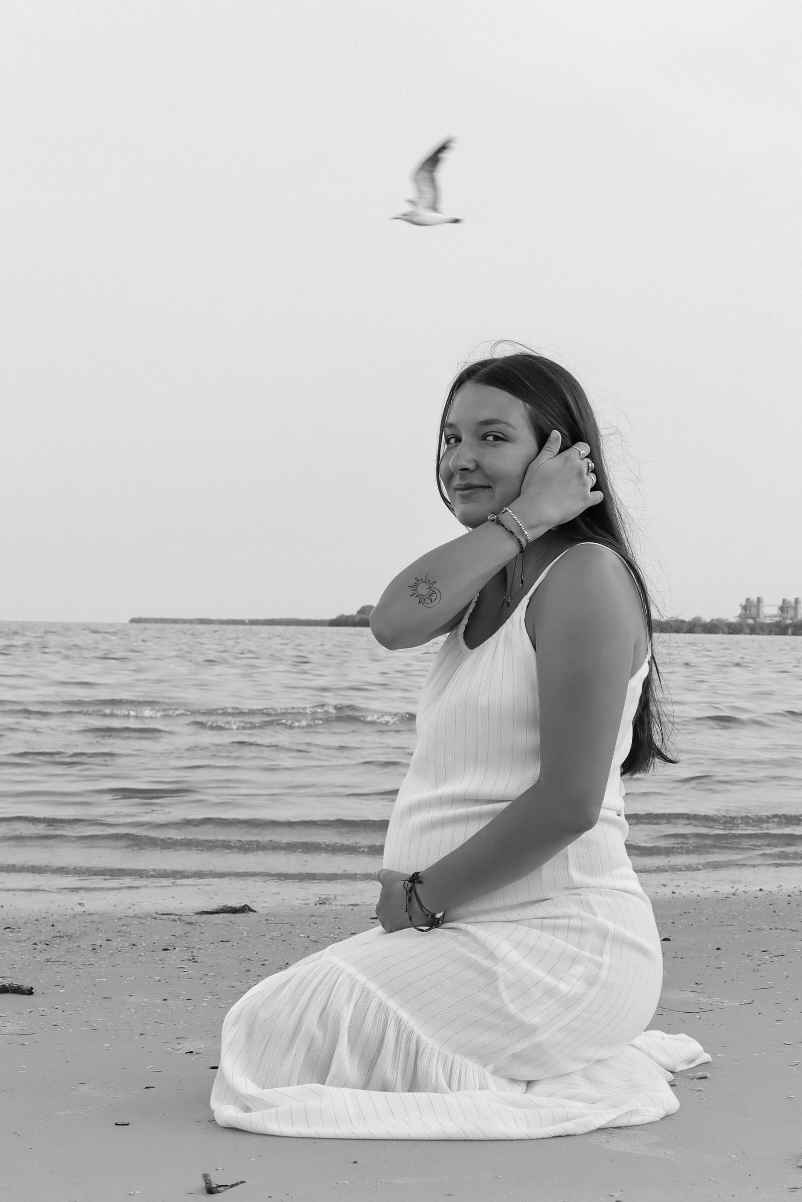 Woman smiling while brushing hair back in black and white in Tampa Bay