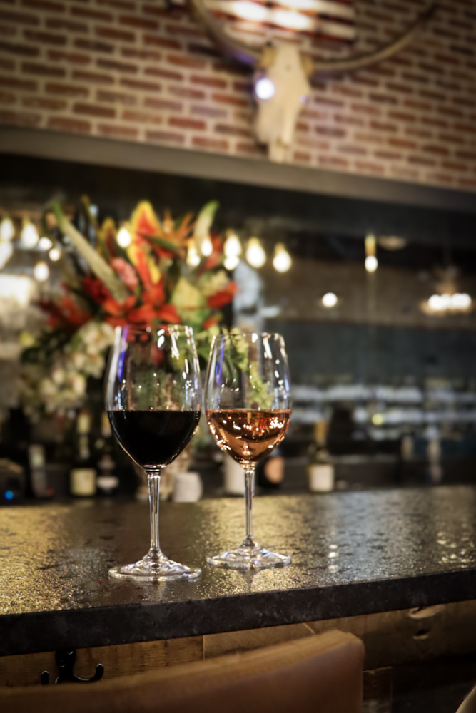 Wine Glass Duo – Product Content Creation Glasses of red and rosé on wooden counter