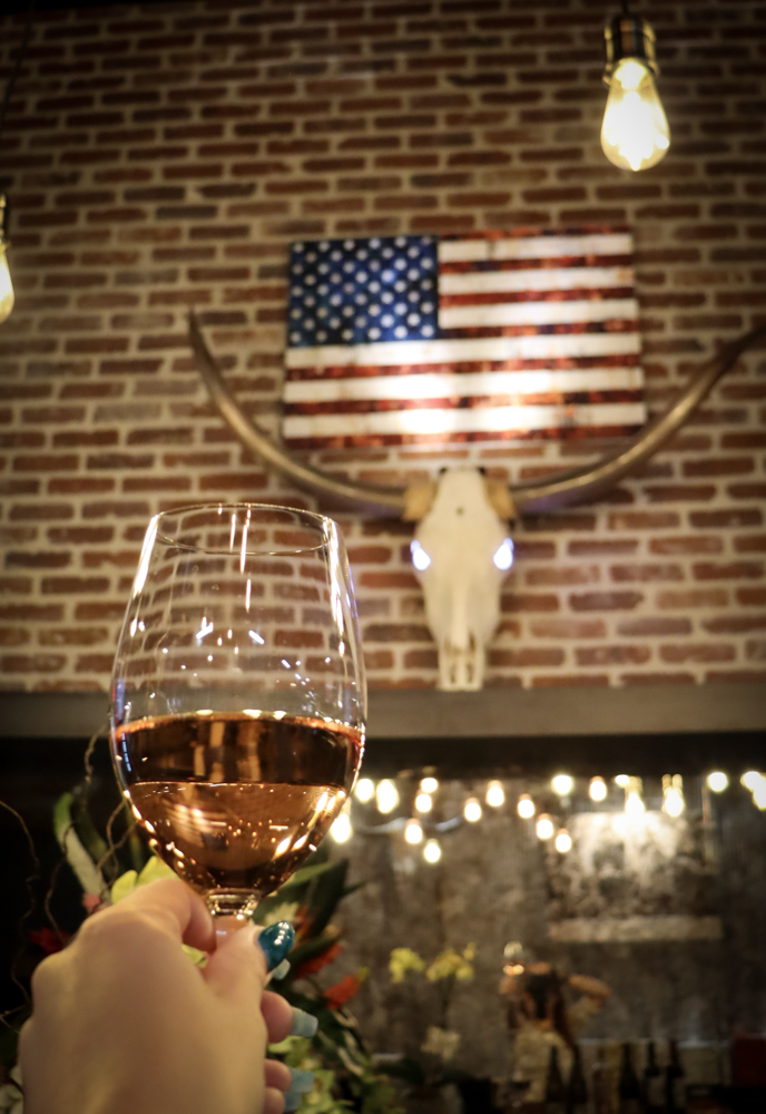 Wine & Americana Wall Art Detail Close-up of wine glass in front of American flag art